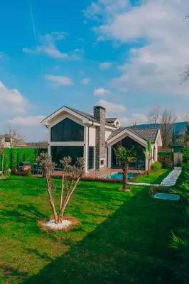 a house with a green yard with a tree at Villa Ulusoy Sapanca in Sapanca