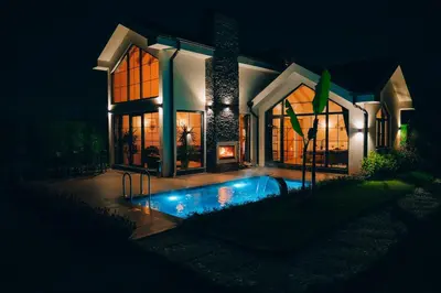 a house with a swimming pool in front of it at night at Villa Ulusoy Sapanca in Sapanca