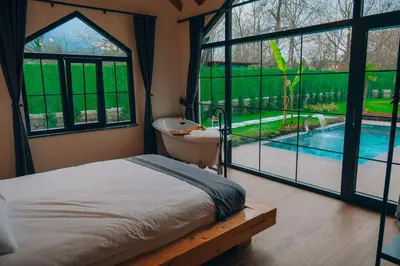 a bedroom with a bed and a tub and a pool at Villa Ulusoy Sapanca in Sapanca