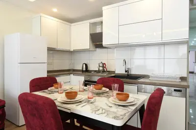a white kitchen with a table and chairs at Uzay Apartments in Istanbul