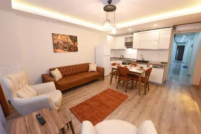 a living room with a couch a table and a kitchen at Uzay Apartments in Istanbul
