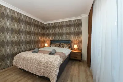 a bedroom with a bed and two lamps on a table at Uzay Apartments in Istanbul