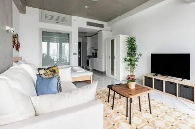 a living room with a white couch and a tv at Cozy Bright Studio! ParkingGymPool Access! #374 in Istanbul