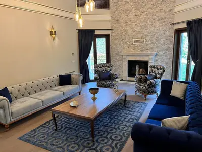 a living room with couches and a table and a fireplace at Nil Konaklama Sapanca in Sapanca