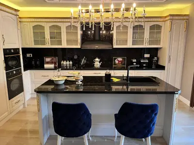 a kitchen with a large island with blue chairs at Nil Konaklama Sapanca in Sapanca