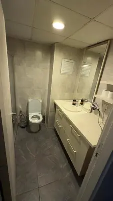 a bathroom with a toilet and a sink and a mirror at Güven Suit in Esenyurt