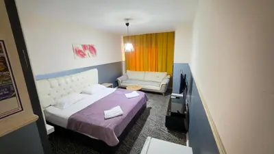 a hotel room with a bed and a couch at Güven Suit in Esenyurt