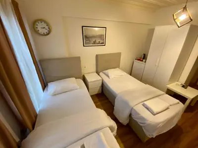 a room with two beds and a clock on the wall at Konak Akaretler Suit in Istanbul