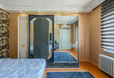 a bedroom with a large mirror in a room at Palas Apartments in Istanbul