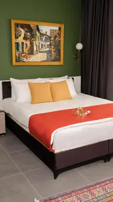 a large bed in a room with a painting on the wall at Zulu Suites in Istanbul