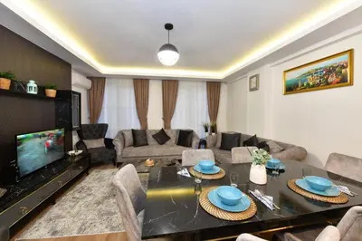 a living room with a table and a tv at Kardes Apartment in Istanbul