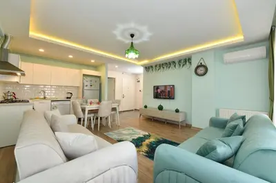 a living room with a large couch and a kitchen at Kardes Apartment in Istanbul