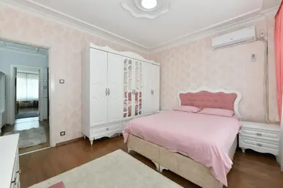 a pink bedroom with a bed and a dresser at Nasiroglu Apartment in Istanbul
