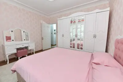 a pink bedroom with a large bed and a dresser at Nasiroglu Apartment in Istanbul