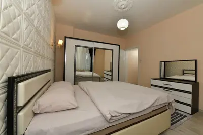 a bedroom with a large bed and a mirror at Sevim Apartment in Istanbul
