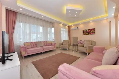 a living room with pink furniture and a tv at Sevim Apartment in Istanbul