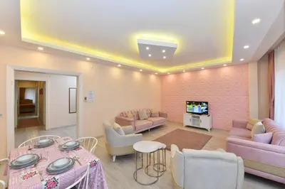 a living room with pink furniture and a tv at Sevim Apartment in Istanbul