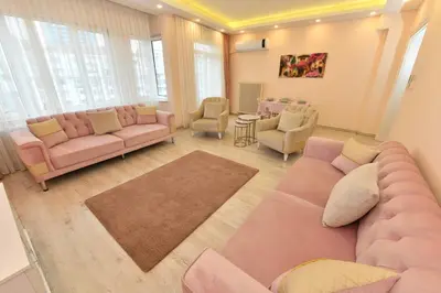 a living room with pink couches and chairs at Sevim Apartment in Istanbul