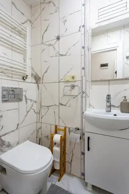 a white bathroom with a toilet and a sink at Lovely and Snug Flat, Just Steps from Istiklal Street in Istanbul