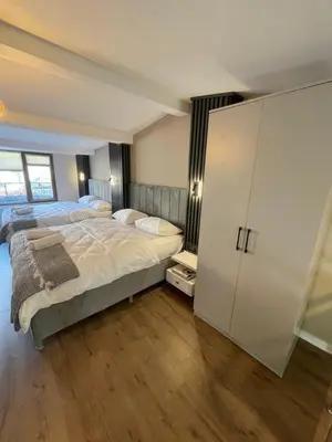 a bedroom with a large bed and a white cabinet at Golden Arrow delüx Dublex in Istanbul