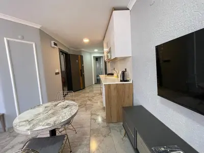 a living room with a tv and a table and a kitchen at Family House in Istanbul