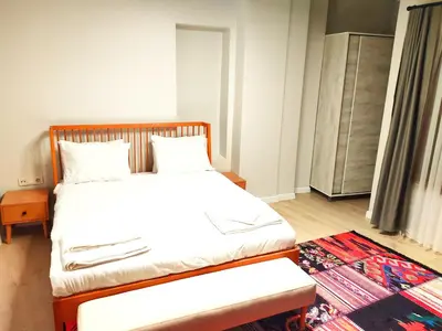 a bedroom with a bed with white sheets and a rug at Million Old City Apartment in Istanbul
