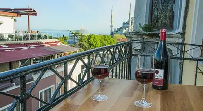 two glasses of wine sitting on a table on a balcony at Million Old City Apartment in Istanbul