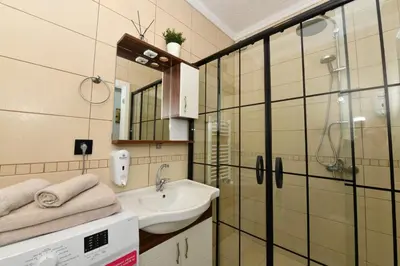 a bathroom with a sink and a glass shower at Bomonti Apartments in Istanbul