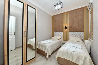 a bedroom with two beds and a mirror at VIP Apartment in Istanbul