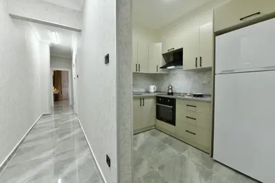 a kitchen with white cabinets and a white refrigerator at VIP Apartment in Istanbul