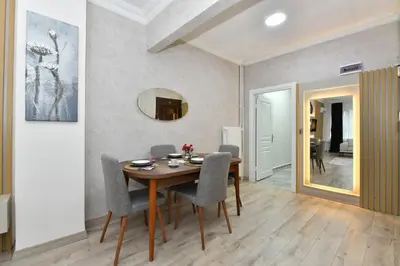 a dining room with a table and chairs and a mirror at VIP Apartment in Istanbul