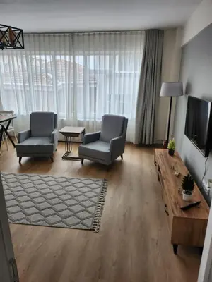 a living room with two chairs and a flat screen tv at Fully Renovated apartment in Istanbul