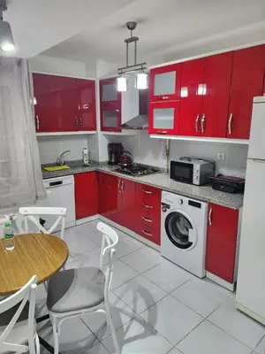 a kitchen with red cabinets and a table and chairs at Fully Renovated apartment in Istanbul