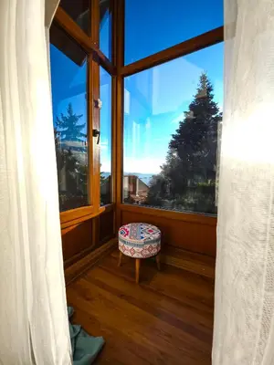 a room with a large window with a bench in front at Uludag Tatil Evleri & Villa Dogus Uludağ in Bursa