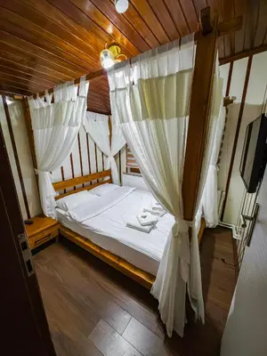 a bedroom with a canopy bed with white curtains at Uludag Tatil Evleri & Villa Dogus Uludağ in Bursa