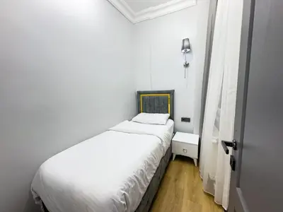 a small white bedroom with a bed and a window at Sisli Holiday 4412 in Istanbul
