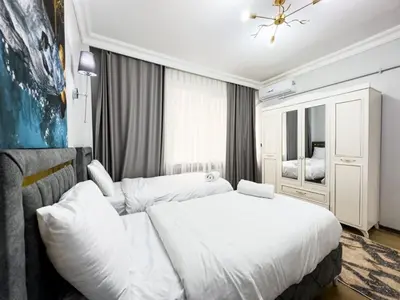 a bedroom with a large white bed and a mirror at Sisli Holiday 4412 in Istanbul
