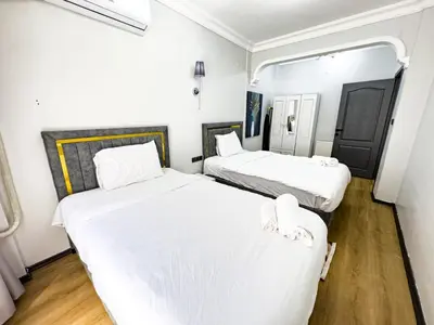 two beds in a small room with white sheets at Sisli Holiday 4412 in Istanbul