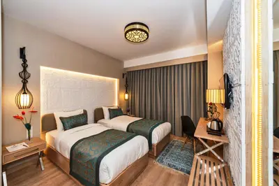 a hotel room with two beds and a table at Aybar Hotel & Spa in Istanbul