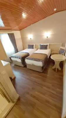 a bedroom with two beds and a table in a room at Sarnic Hotel & Sarnic Premier Hotel(Ottoman Mansion) in Istanbul