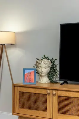 a tv sitting on top of a cabinet with a bust at Respiro Rooms in Istanbul