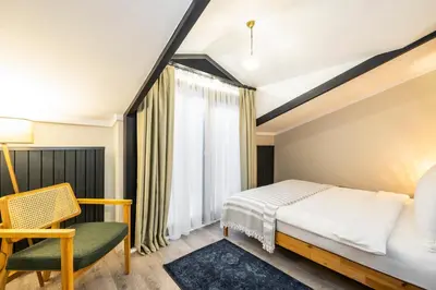 a bedroom with a bed and a chair and a window at Respiro Rooms in Istanbul