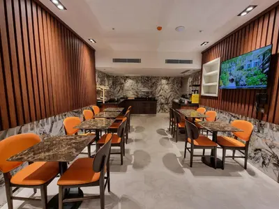a restaurant with tables and chairs and a large screen at RIJJI HOTEL ISTANBUL OLD CiTY in Istanbul