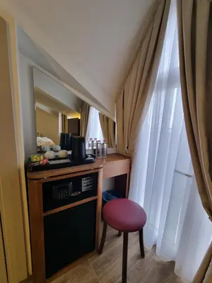 a small kitchen with a table and a red stool at RIJJI HOTEL ISTANBUL OLD CiTY in Istanbul