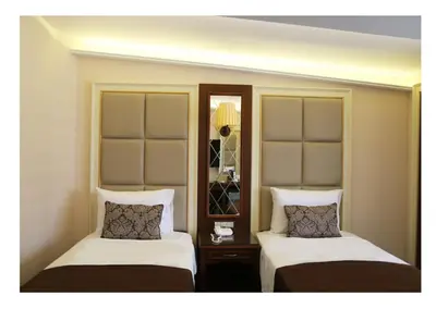 two beds in a hotel room with white sheets at Fimka Hotel in Istanbul