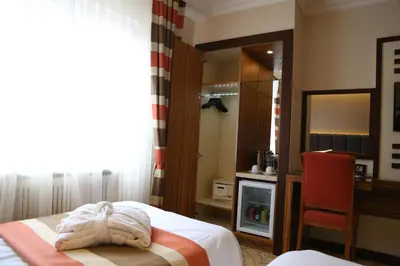 a bedroom with a bed and a chair and a mirror at Fimka Hotel in Istanbul