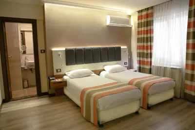 a hotel room with two beds and a bathroom at Fimka Hotel in Istanbul