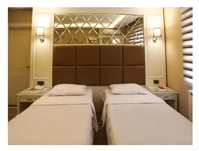 two beds in a small room with two lamps at Fimka Hotel in Istanbul