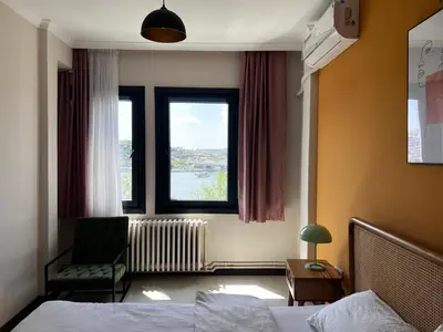 a bedroom with a bed and a window and a chair at Astounding Sea View Apartment in Karaköy 4BR, 2BA in Istanbul