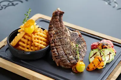 a plate with steak and waffle fries and a bowl of food at Uranus Istanbul Topkapi in Istanbul